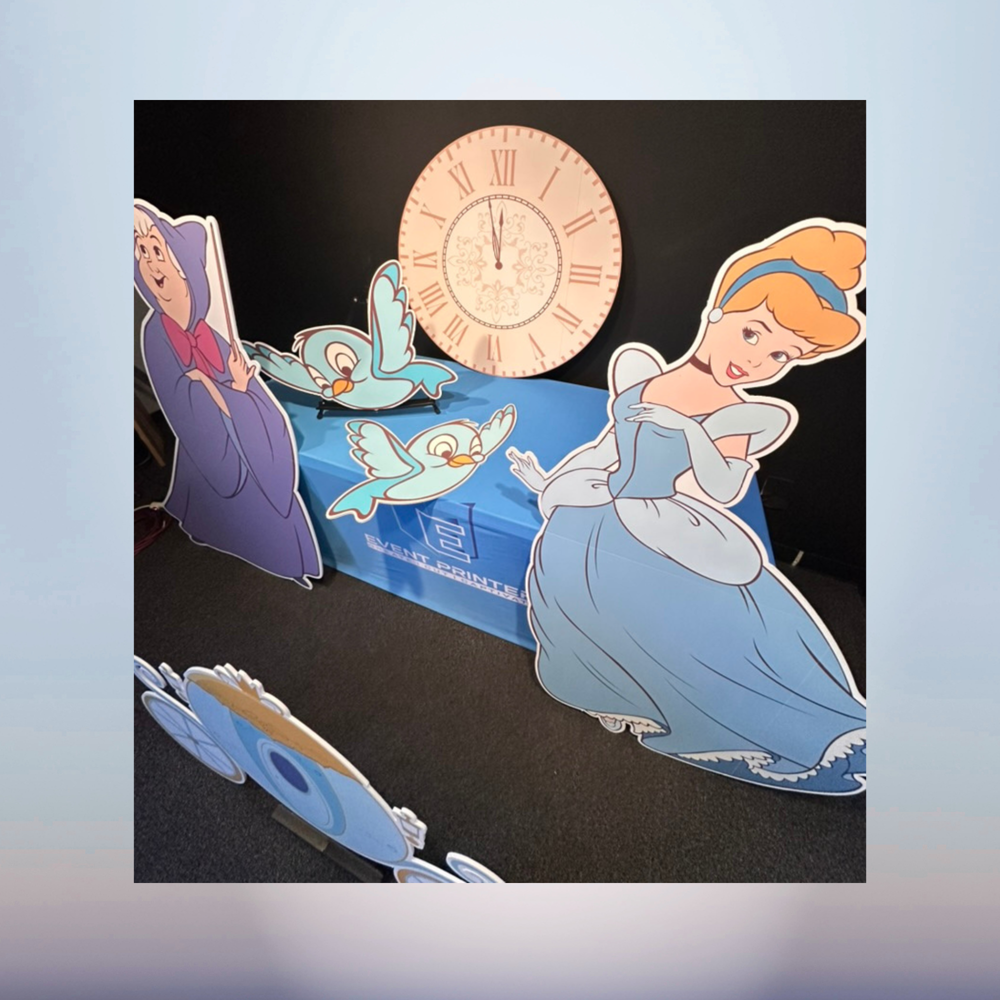Cinderella princess and clock character cutouts for a fairytale baby shower display