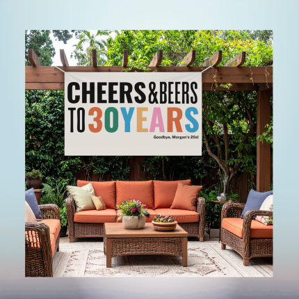 Custom retirement vinyl banner hanging outdoors over a backyard seating area.