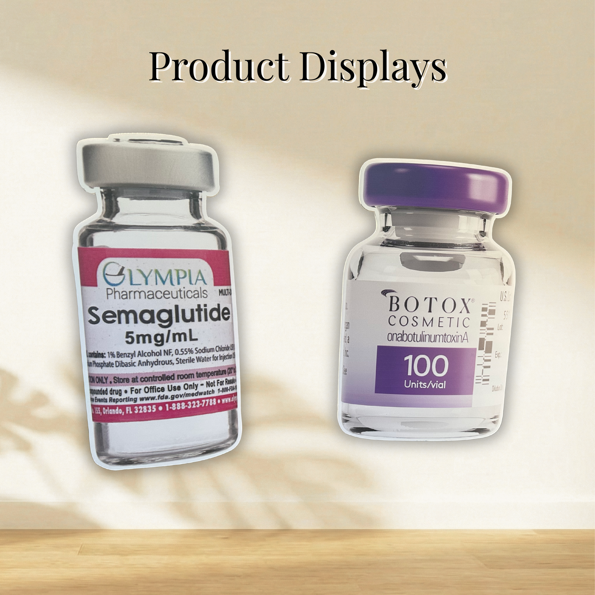 Two oversized die-cut foam board displays shaped like pharmaceutical product vials