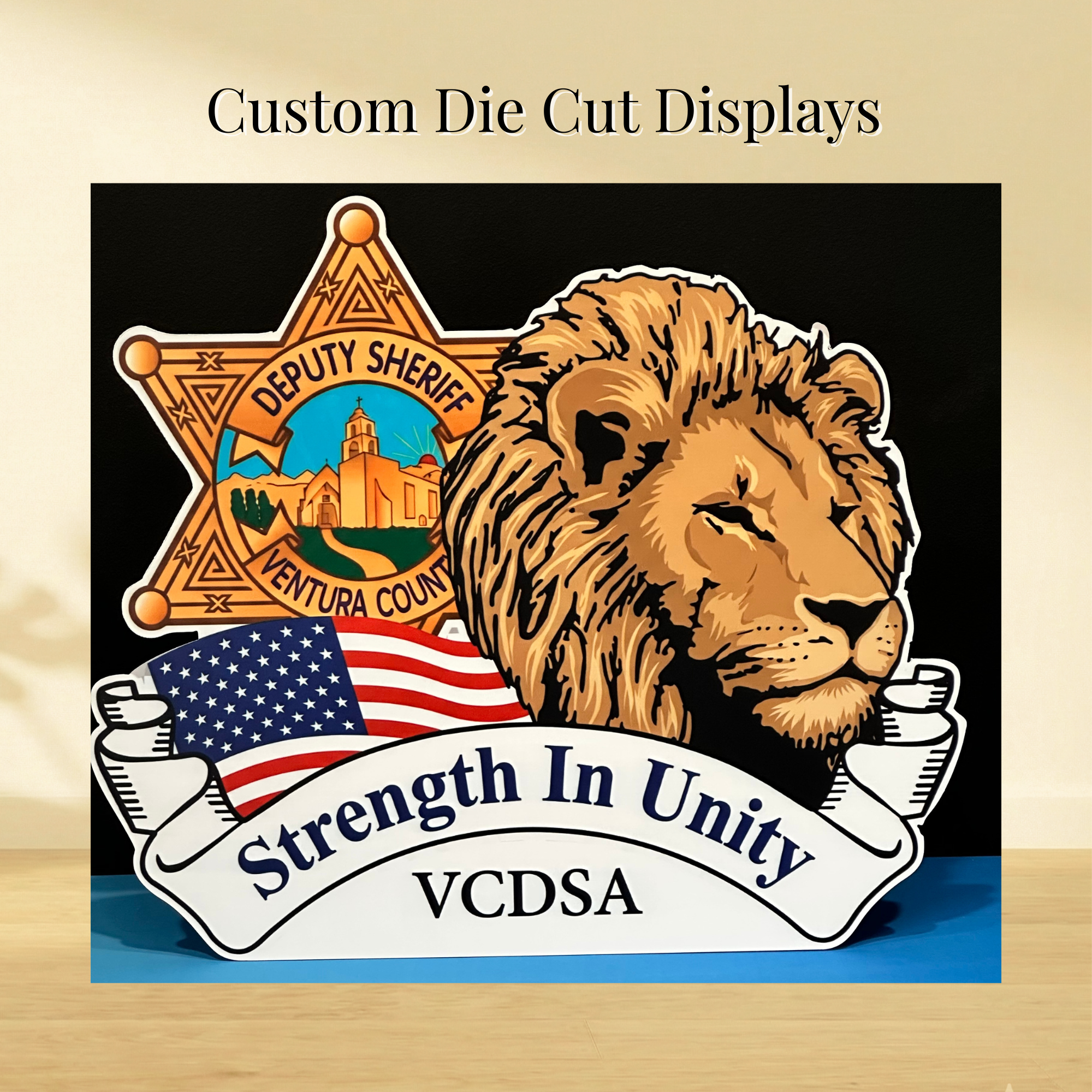 Custom die-cut display featuring a Ventura County deputy sheriff badge, lion, American flag and Strength in Unity banner