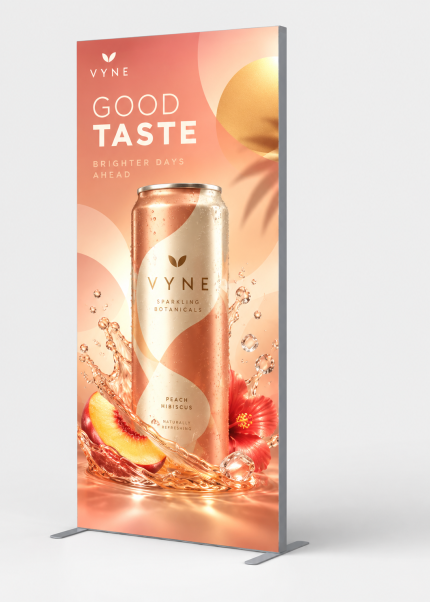 Front view of a custom SEG fabric stand with peach beverage artwork and freestanding frame